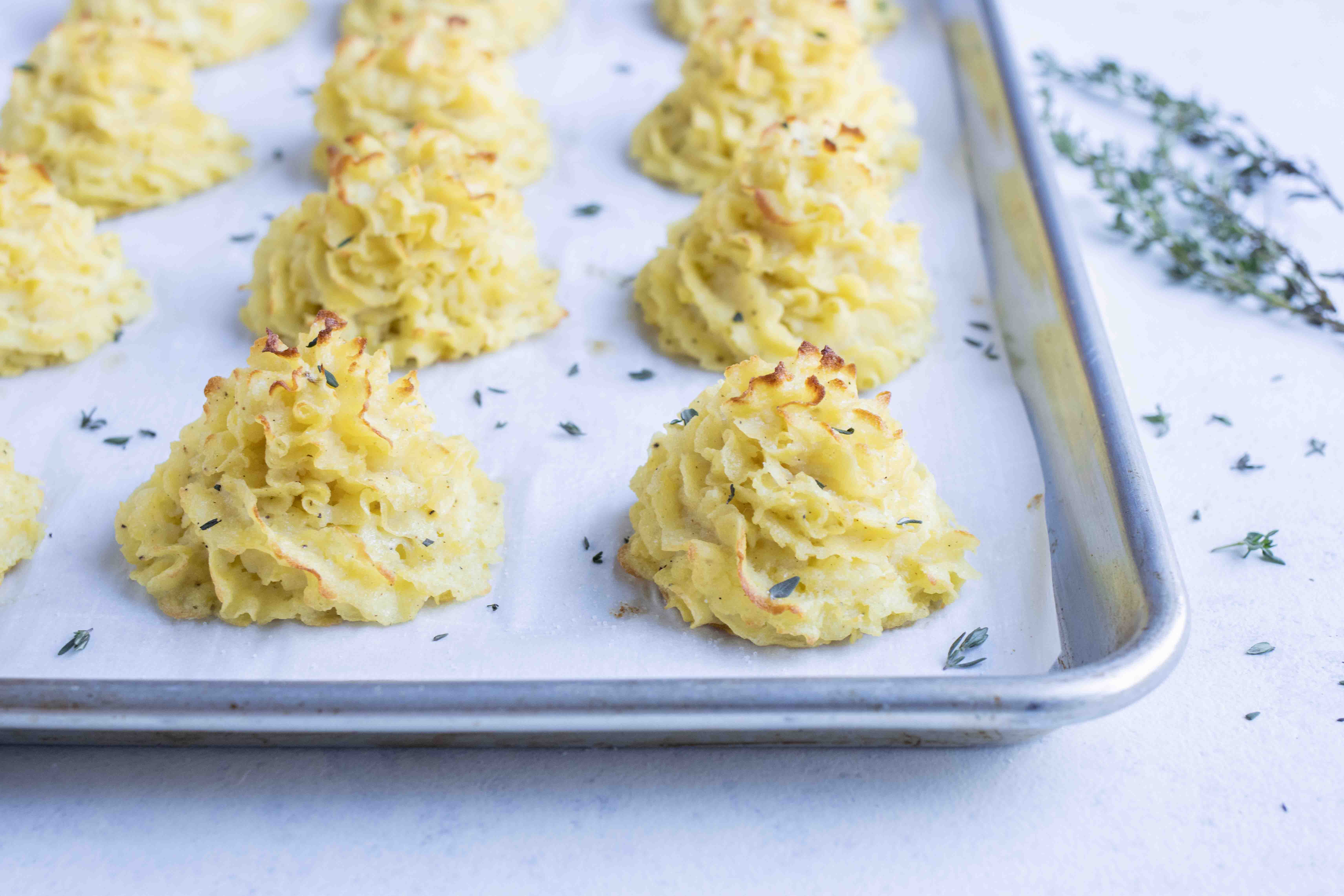 A baking sheet of golden duchess potatoes made without heavy cream