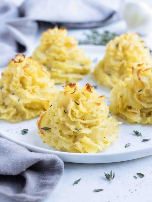 A plate is used to serve these decadent duchess potatoes.