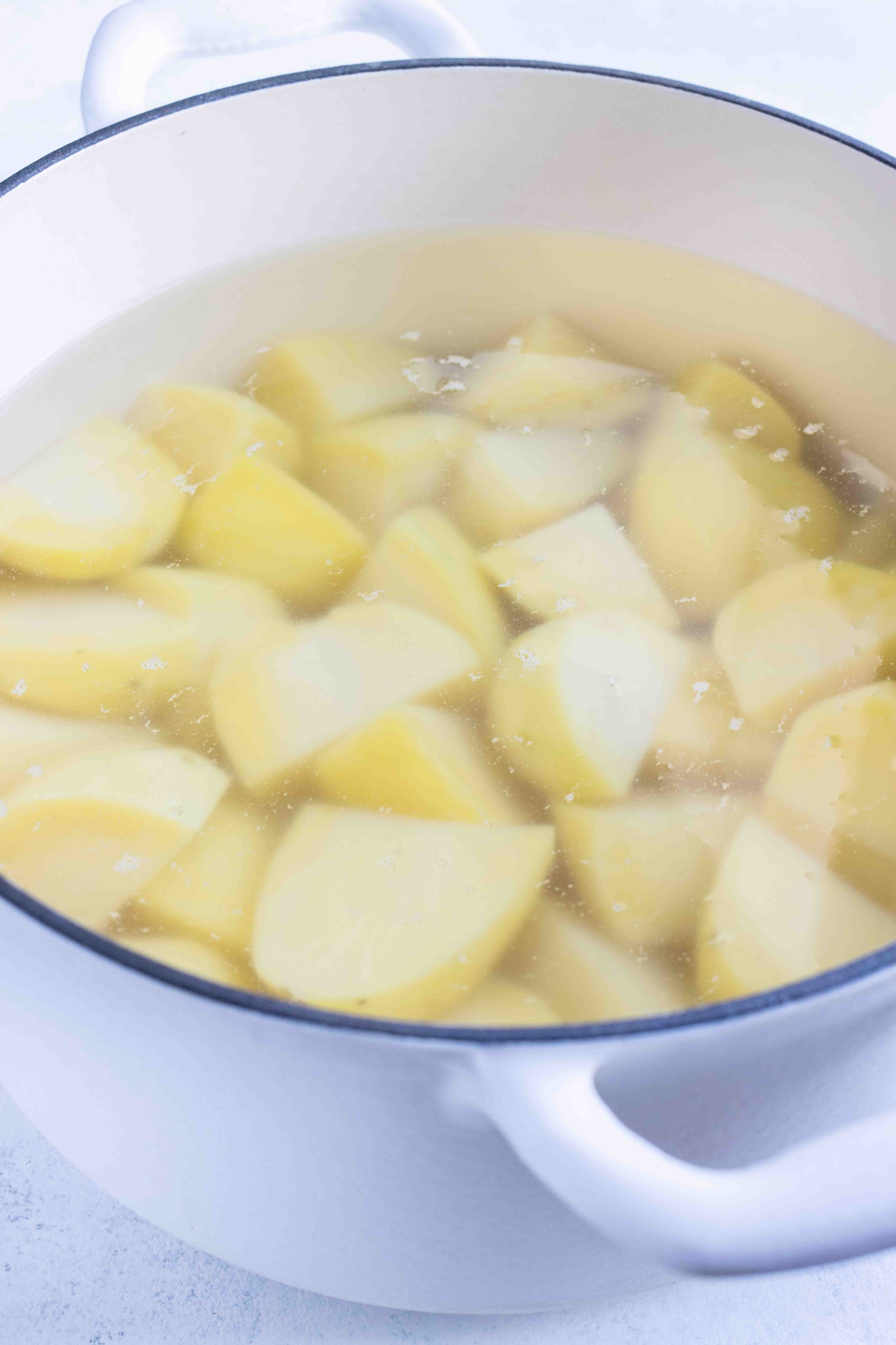 A boiling pot of water is used to cook potatoes.