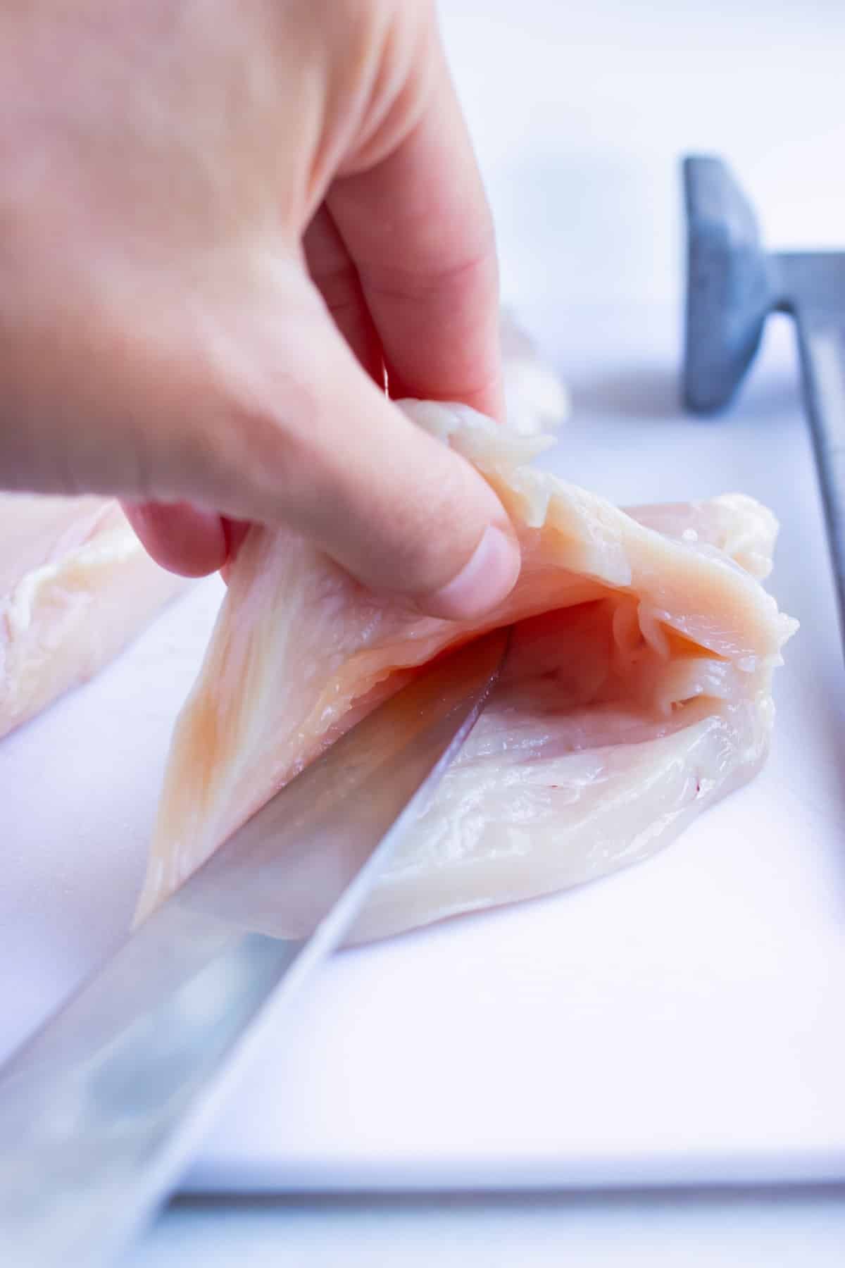 Chicken breasts are cut open before being stuffed with spinach artichoke dip.