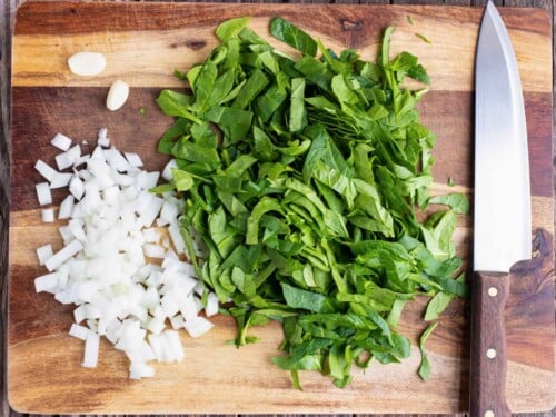 Finely chopped fresh spinach and diced onion to go into a spinach crustless quiche recipe.