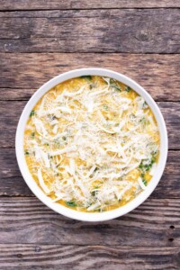 Cheese is sprinkled on top of the quiche mix before baking.