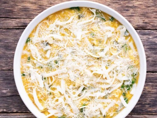 Cheese is sprinkled on top of the quiche mix before baking.