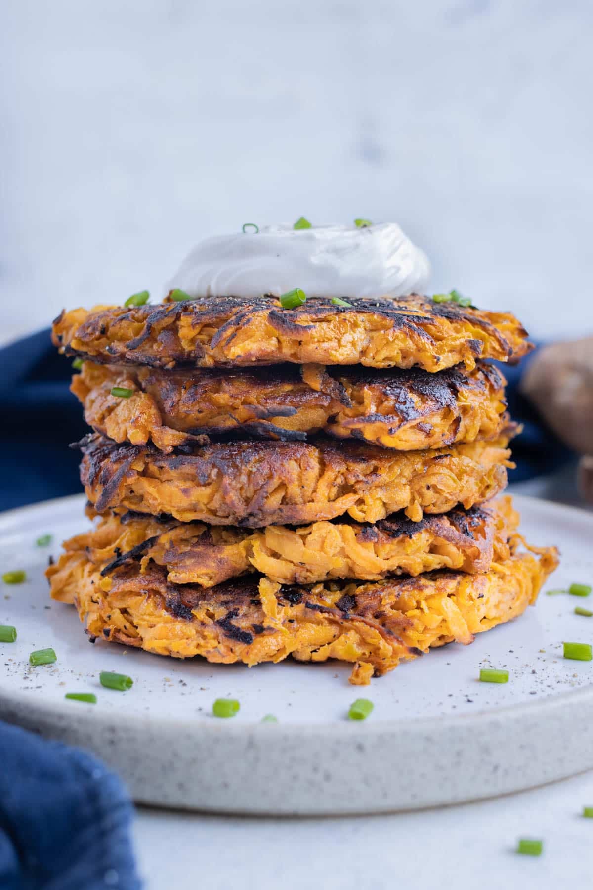 Sweet potato hash browns topped with sour cream and chives for a breakfast side dish.