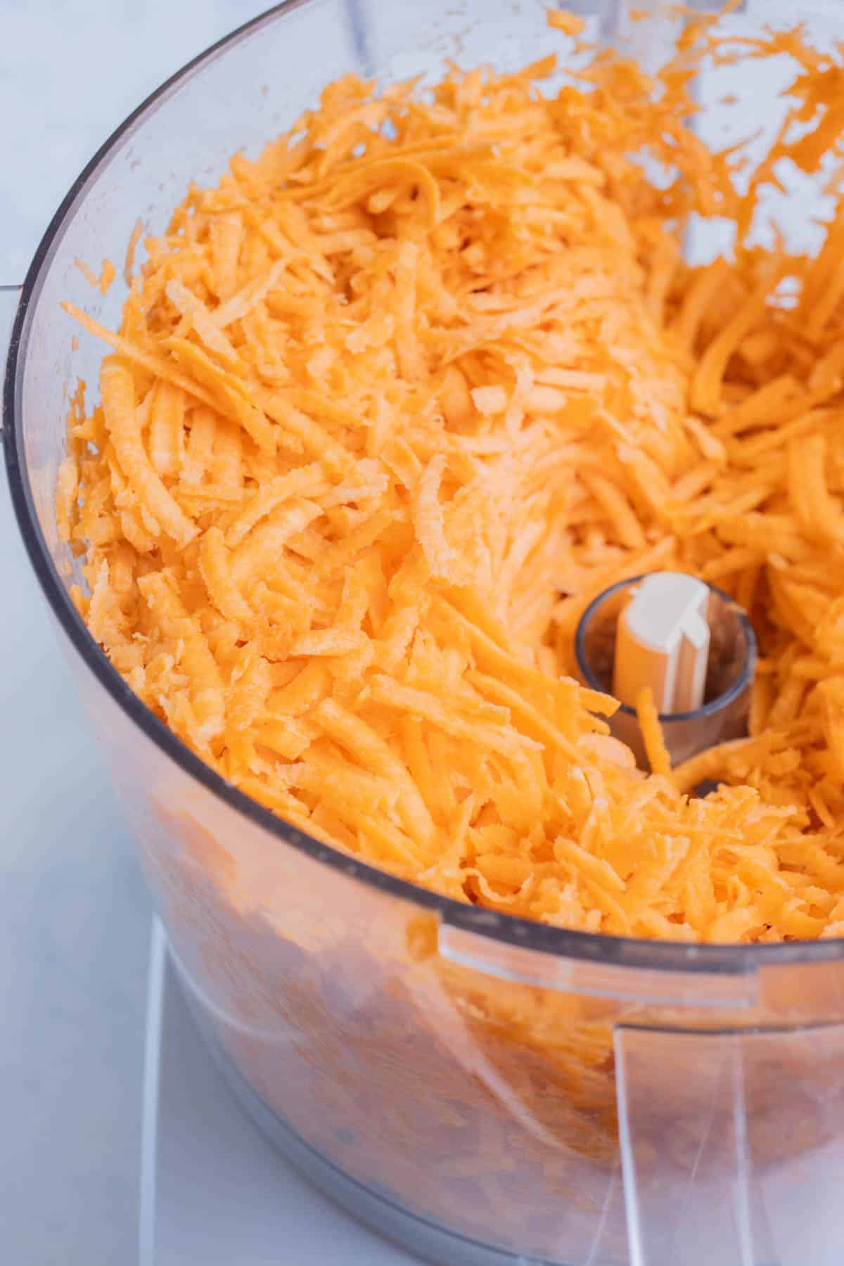 Sweet potatoes are grated in a food processor.