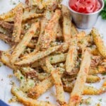 Parmesan garlic fries are served on a white tray with ketchup.