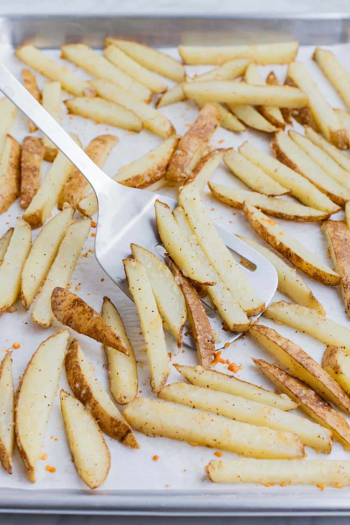 Sliced potatoes are seasoned before baking.