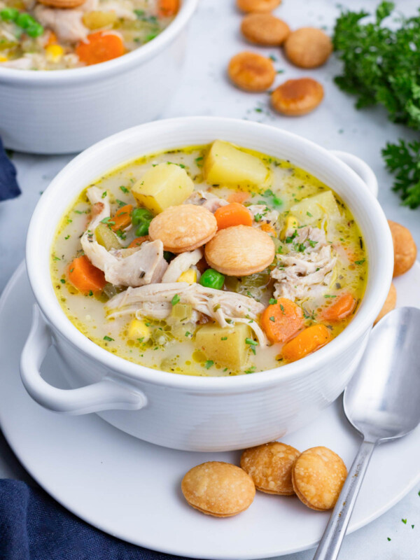A healthy chicken pot pie soup recipe is served in a white bowl.