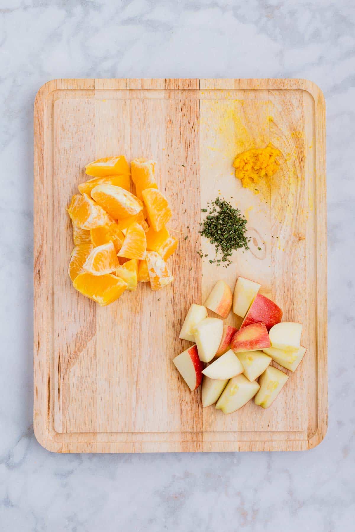 Apple, orange, and herbs are prepped for this recipe.