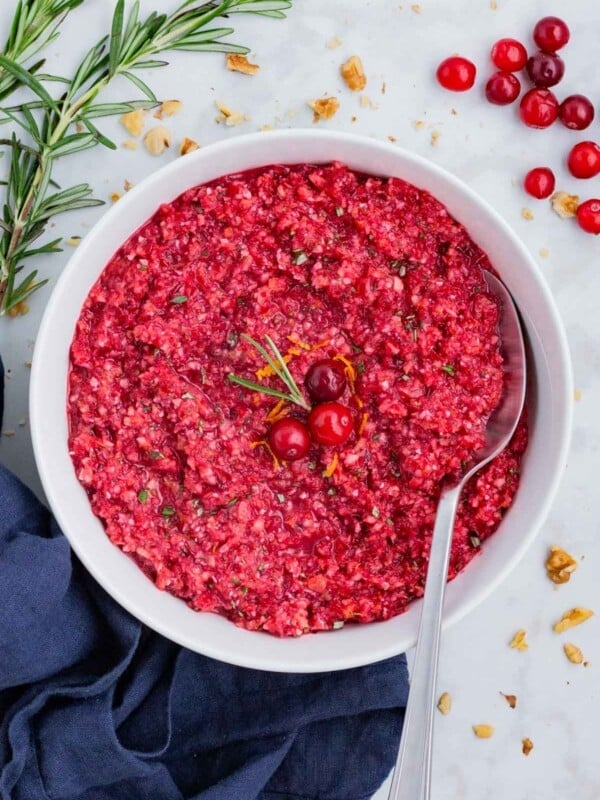 A metal spoon is used to serve this orange cranberry relish.