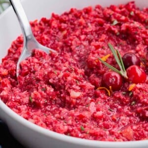A metal spoon is used to serve this orange cranberry relish.