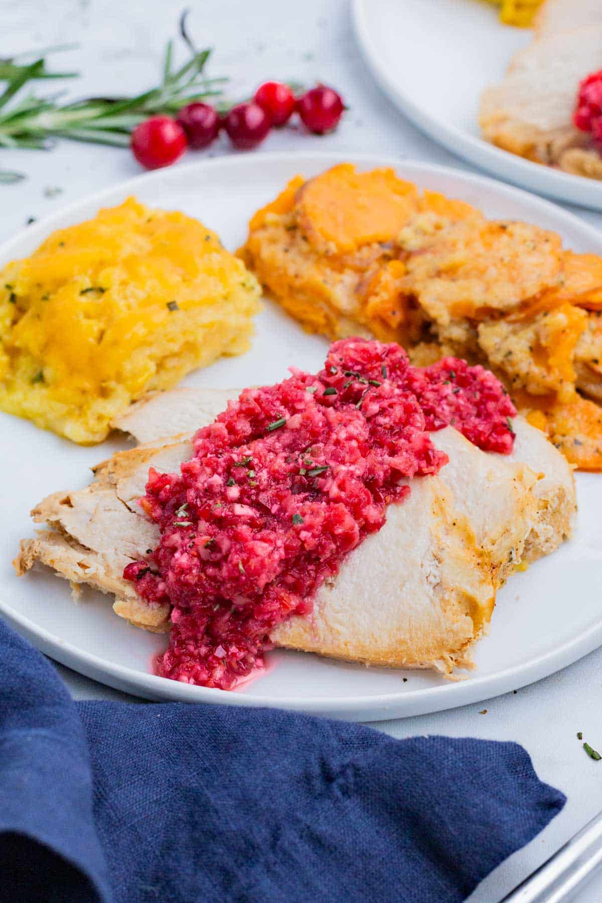 Orange cranberry relish is served over turkey at a holiday meal.