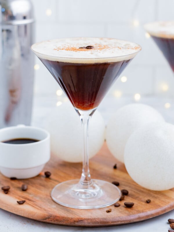 An espresso martini is served in a tall martini glass.