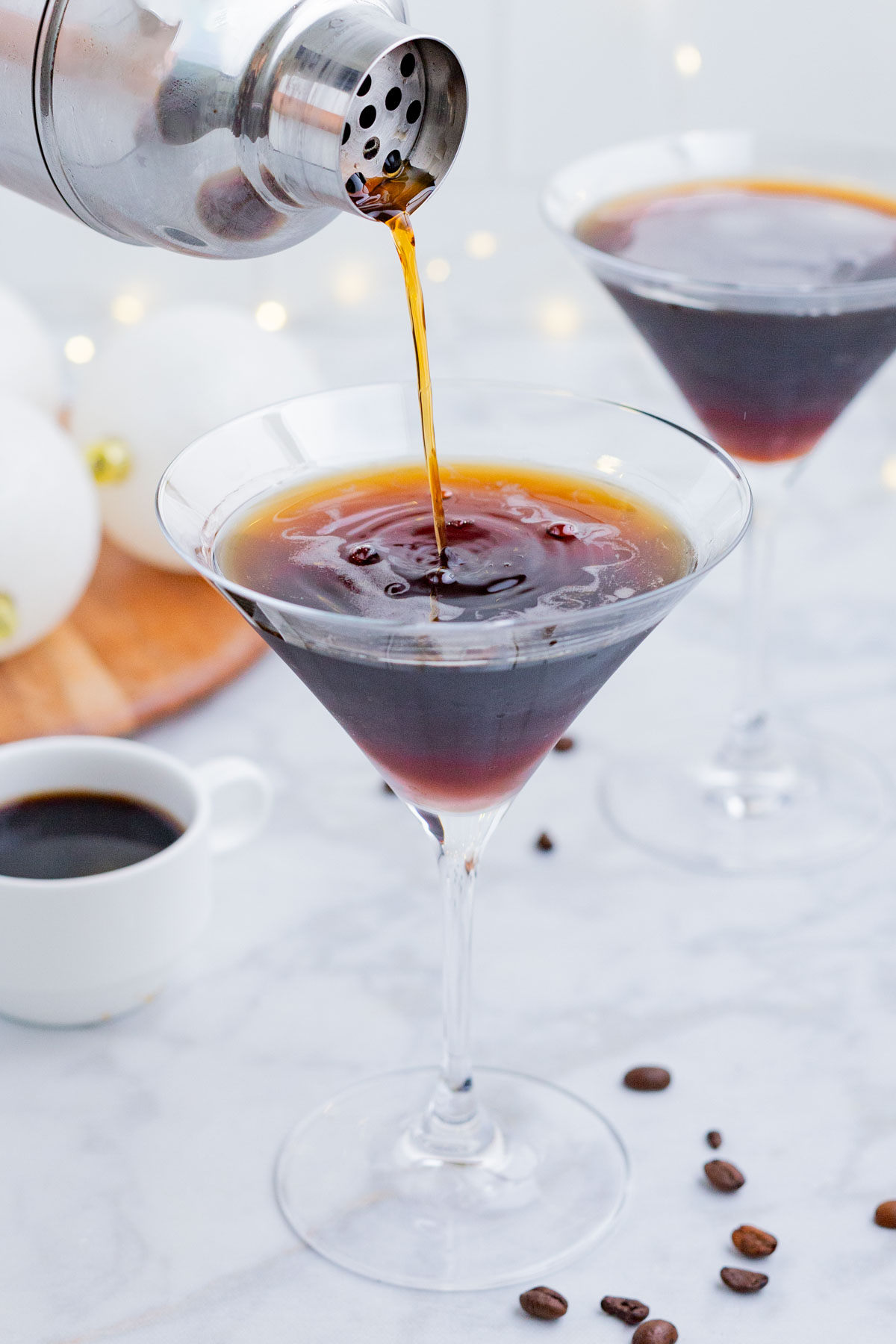A shaken espresso martini is poured into a martini glass.