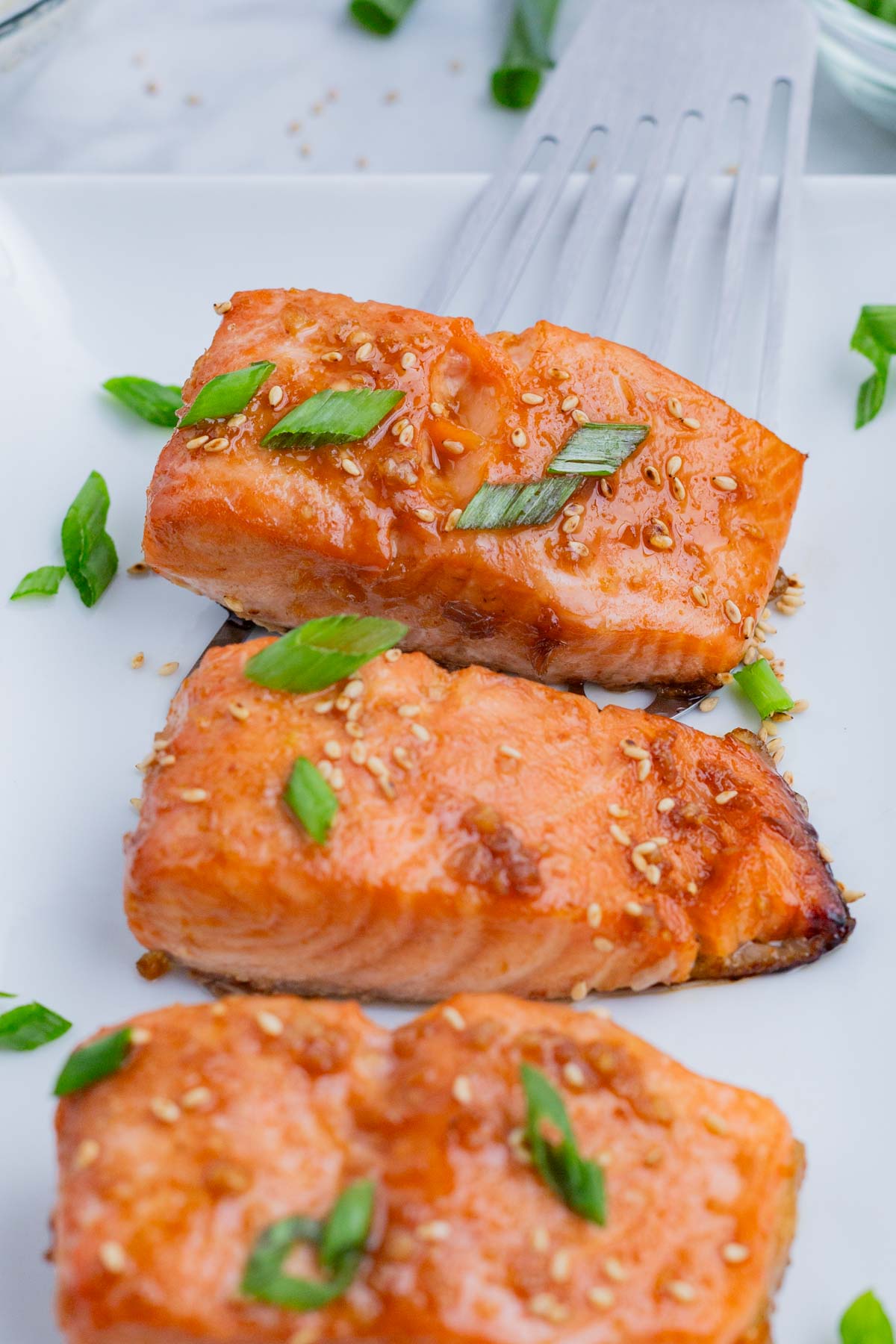 Salmon fillets are served on a long, white, rectangular serving platter.