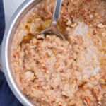 Oatmeal is cooked in a pot and flavored with maple syrup and brown sugar.