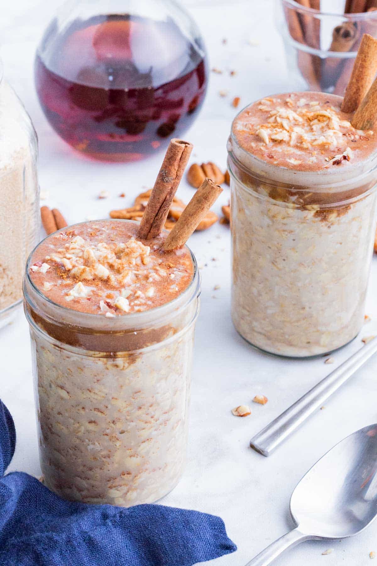 Two jars of gluten-free overnight oats made with maple, brown sugar, and cinnamon for a healthy breakfast.