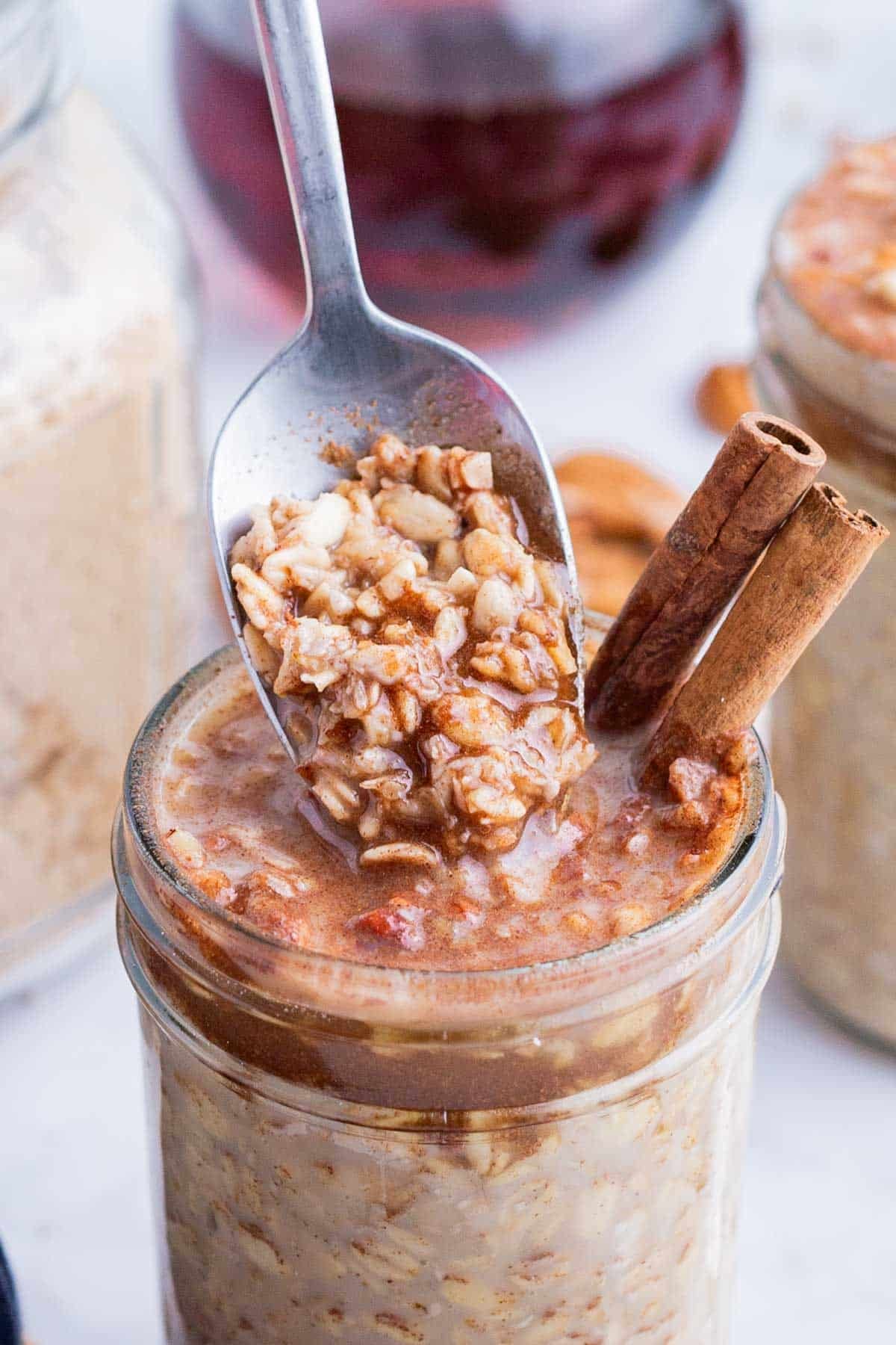 A spoon digs into a jar of maple brown sugar oatmeal made in the fridge overnight.