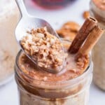 A spoon digs into a jar of maple brown sugar oatmeal made in the fridge overnight.