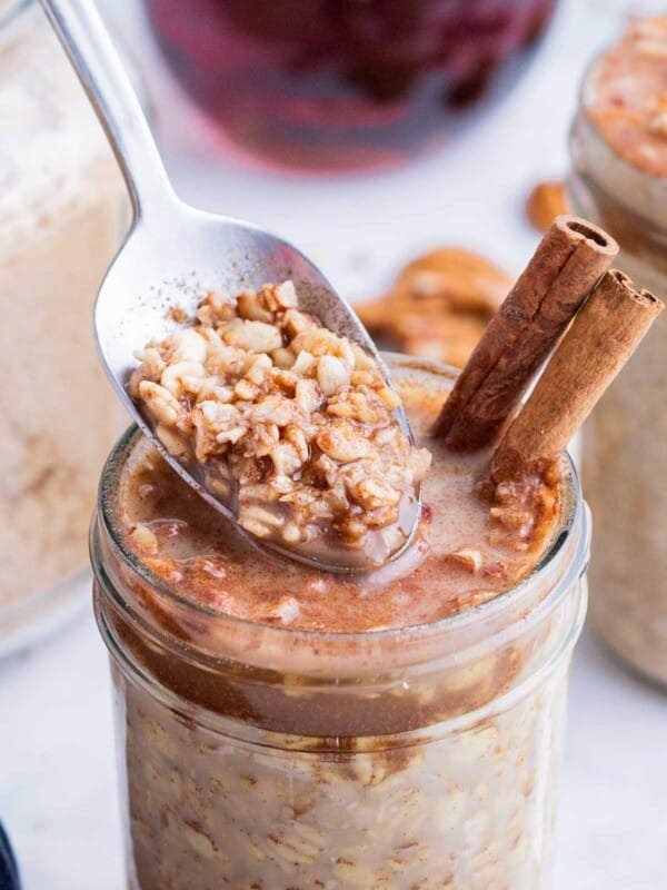 A spoon digs into a jar of maple brown sugar oatmeal made in the fridge overnight.