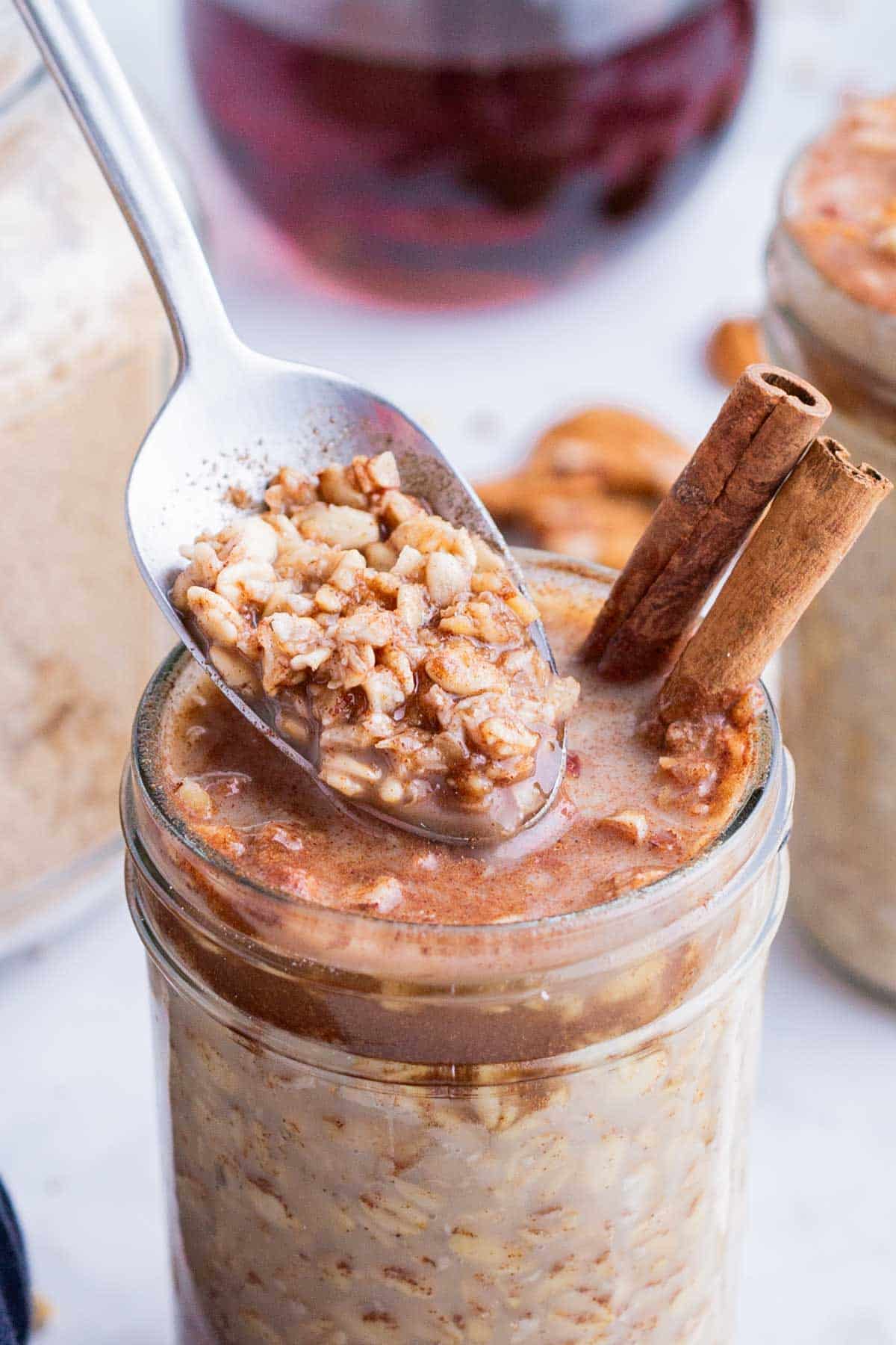 A spoon digs into a jar of maple brown sugar oatmeal made in the fridge overnight.