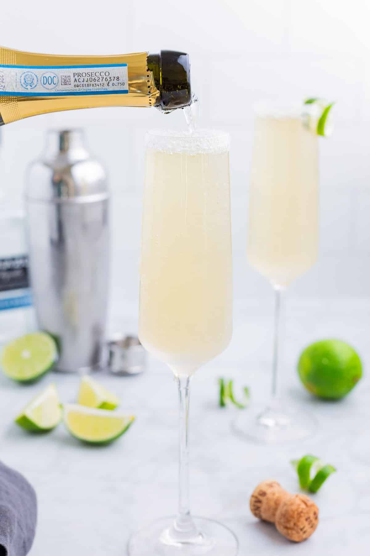 Champagne is added to a champagne flute to finish the Mexican 75 cocktail.