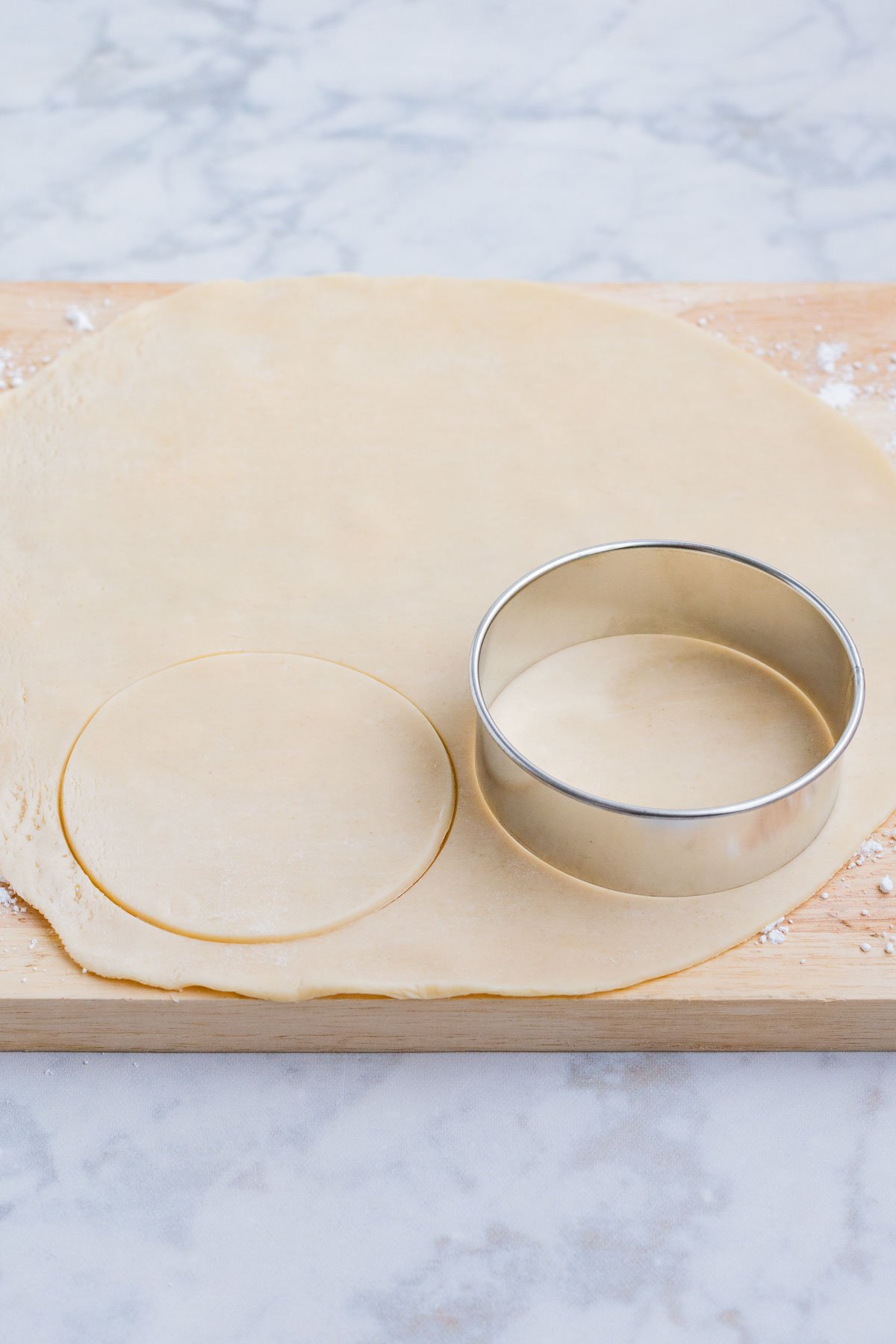 A large cookie cutter cuts circles into the rolled out pie crust.