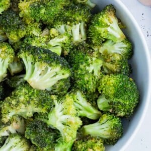 Honey-roasted broccoli is served in a white bowl.