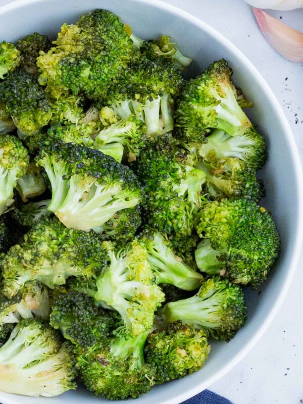 Honey-roasted broccoli is served in a white bowl.