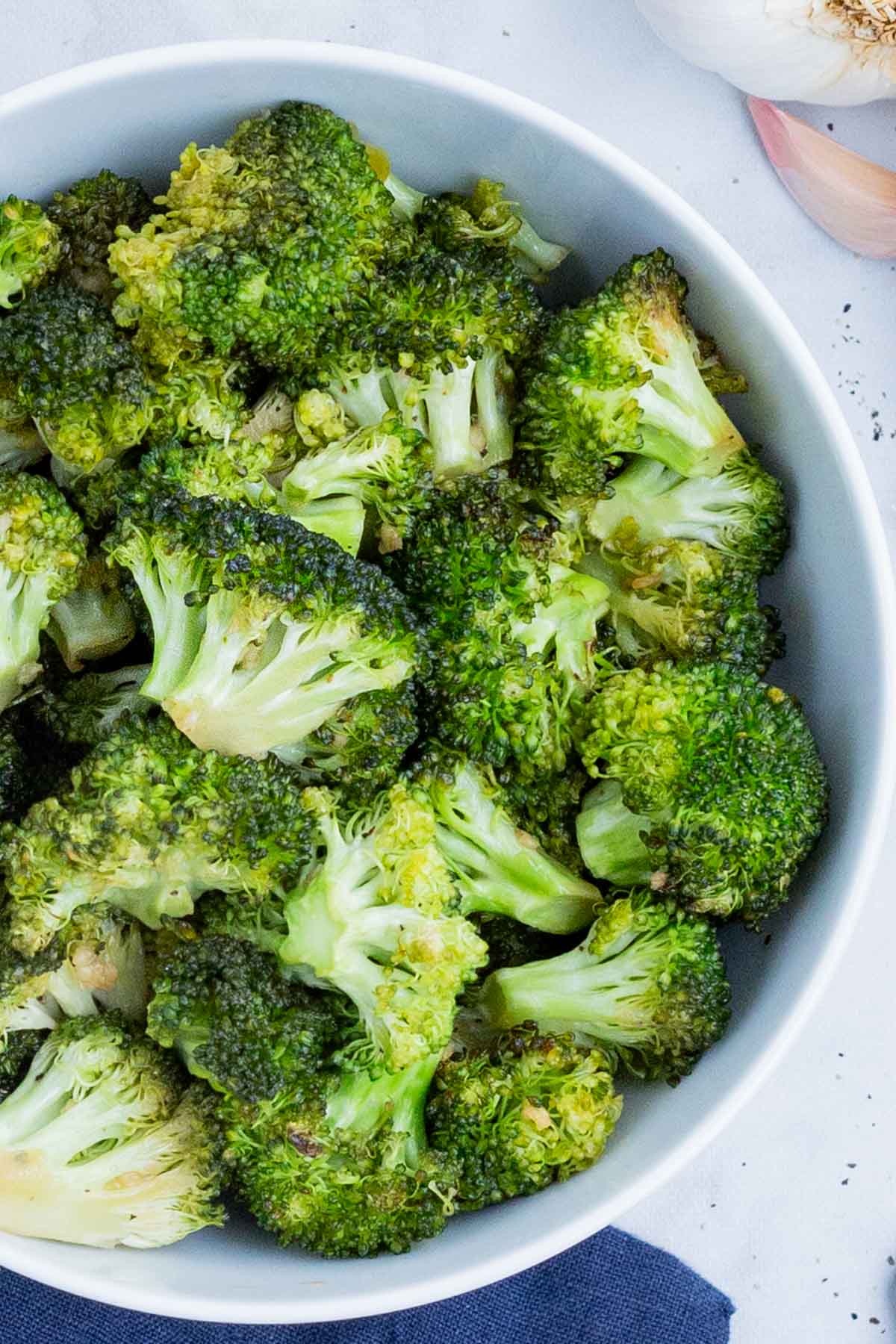 Honey roasted broccoli is served in a white bowl.
