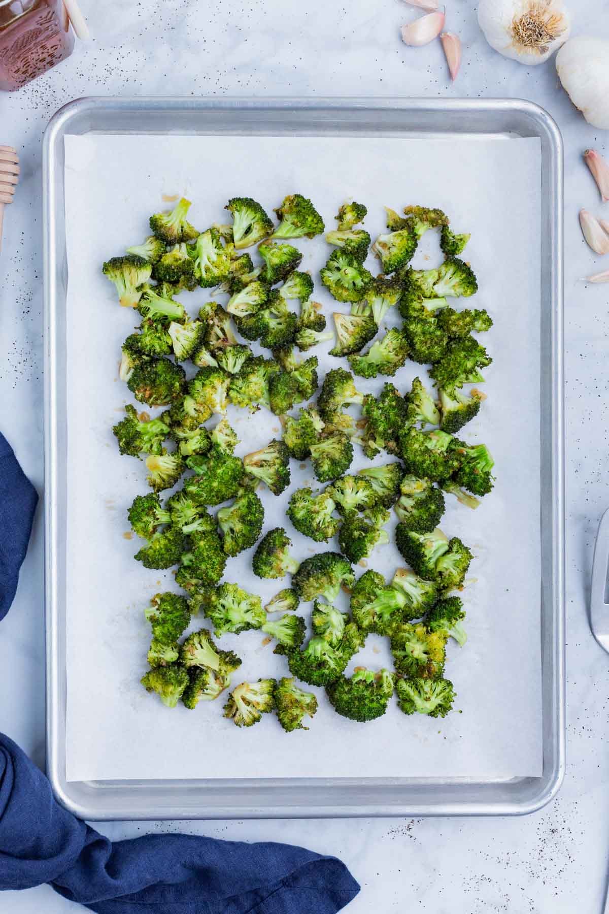 Honey broccoli is roasted on a baking sheet.