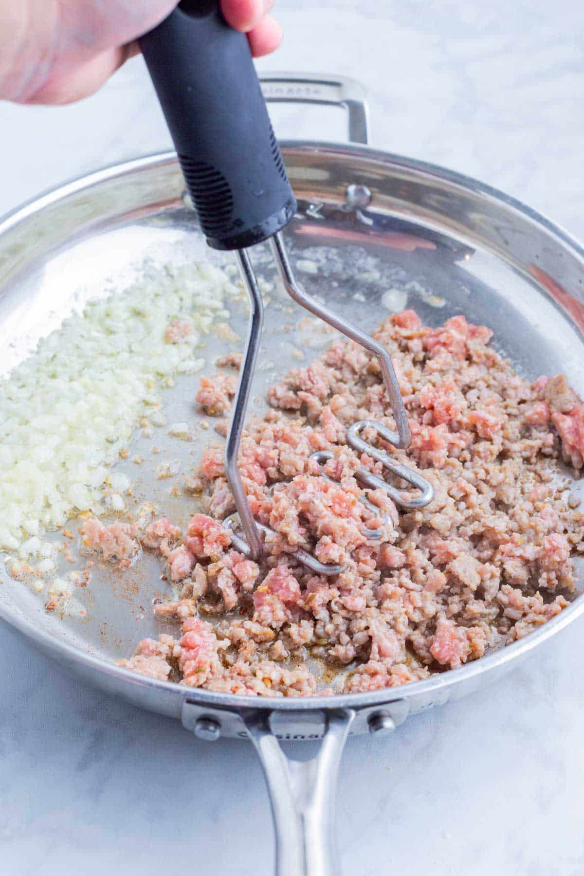 Meat is added to the skillet with the onion and garlic.