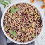 A spoon is used to dig into a bowl of wild rice stuffing.