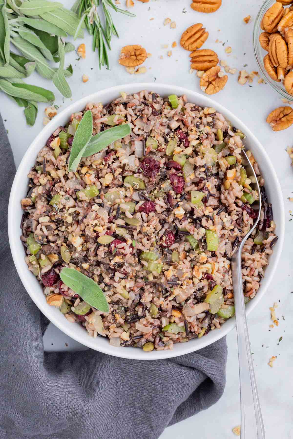 A spoon is used to dig into a bowl of wild rice stuffing.