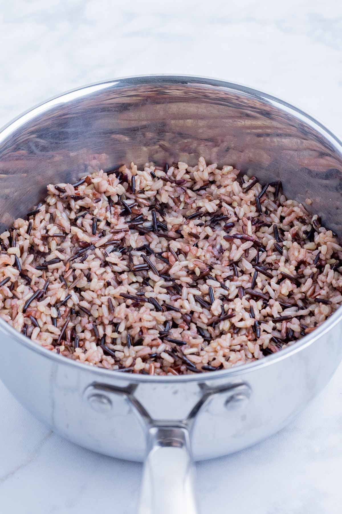 The wild rice is cooked completely on the stove.