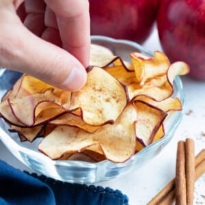 A bowl of apple chips is enjoyed for a healthy snack.
