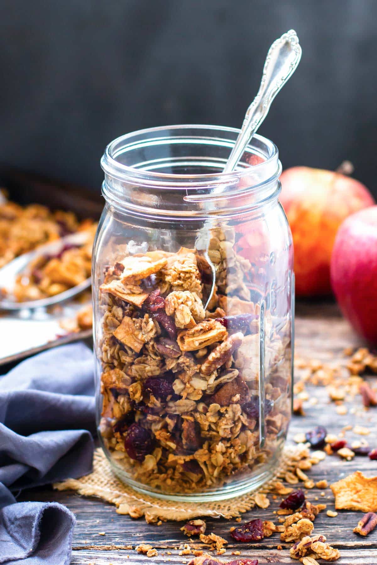 A jar of apple cinnamon granola with a spoon.