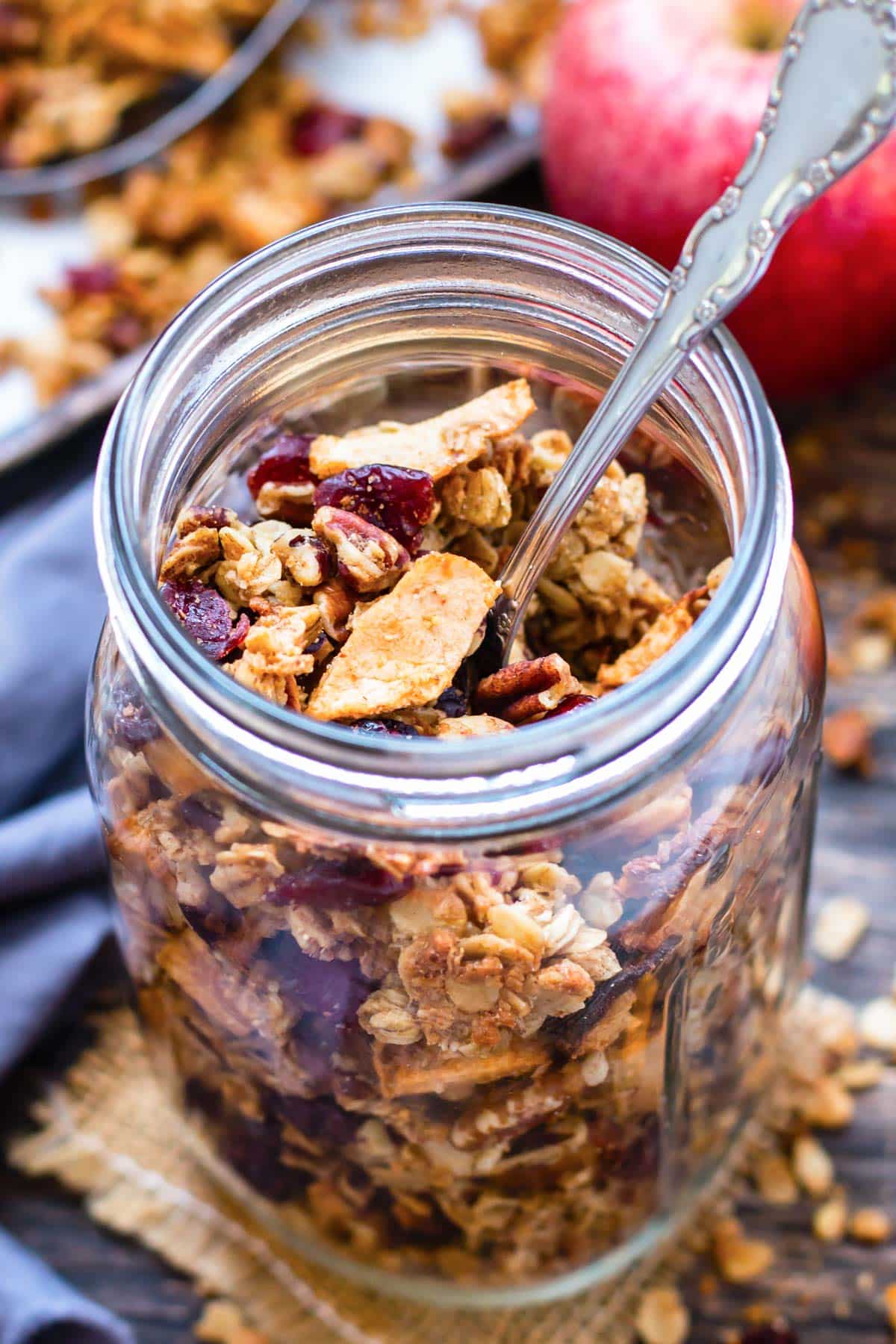 A jar of apple cinnamon granola, studded with pecans and cranberries.