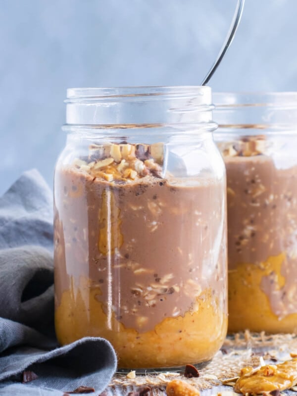 Two glass jars filled with gluten-free Healthy Chocolate Peanut Butter Overnight Oats.