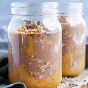 Two glass jars of vegan overnight oats recipe with a gray napkin.