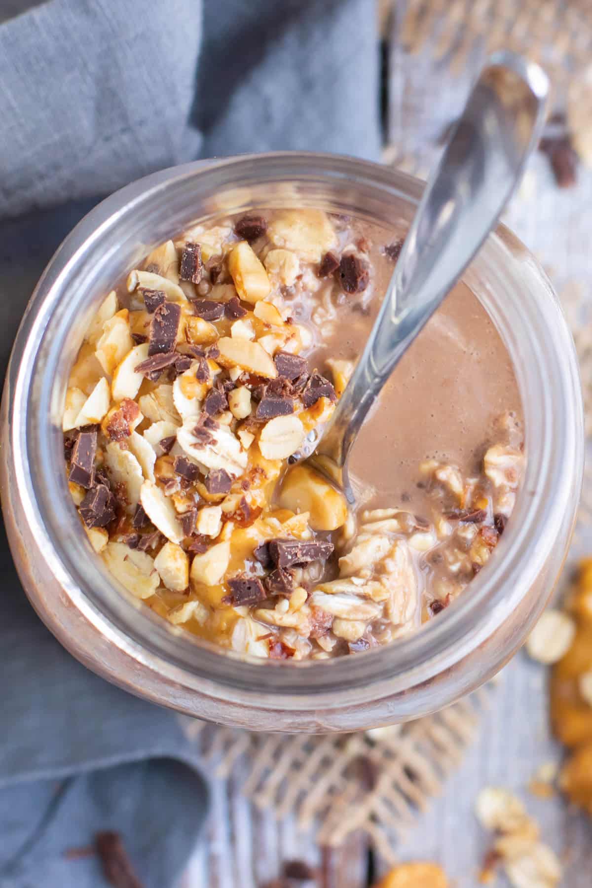Overhead picture of healthy gluten-free peanut butter overnight oats in a glass jar with a spoon.
