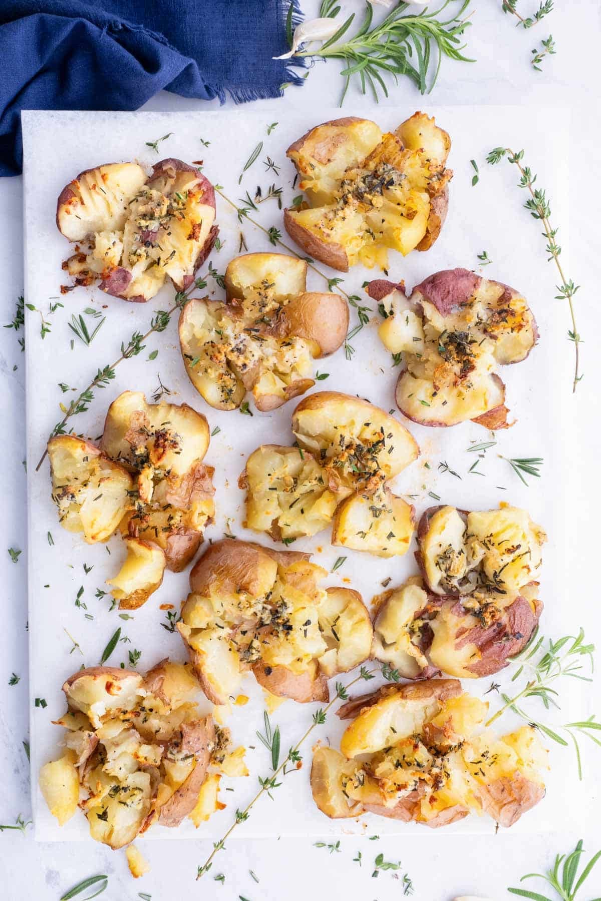 Gluten-free crispy smashed potatoes on a baking sheet lined with parchment paper.