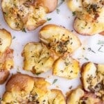Gluten-free crispy smashed potatoes on a baking sheet lined with parchment paper.