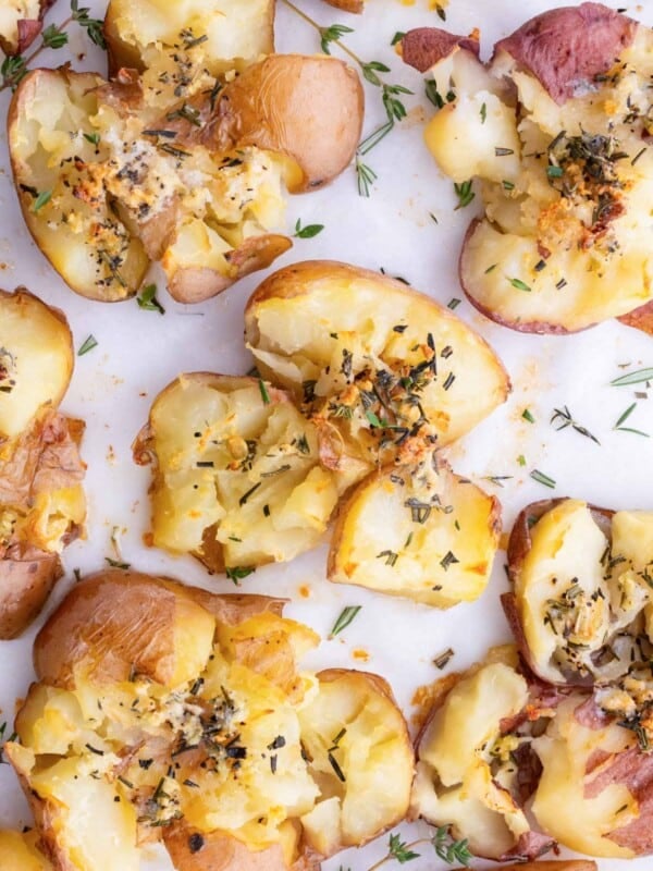 Gluten-free crispy smashed potatoes on a baking sheet lined with parchment paper.