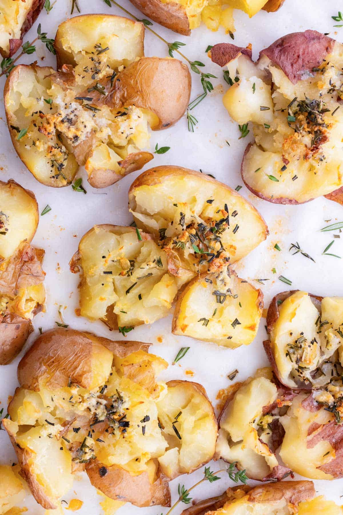 Gluten-free crispy smashed potatoes on a baking sheet lined with parchment paper.