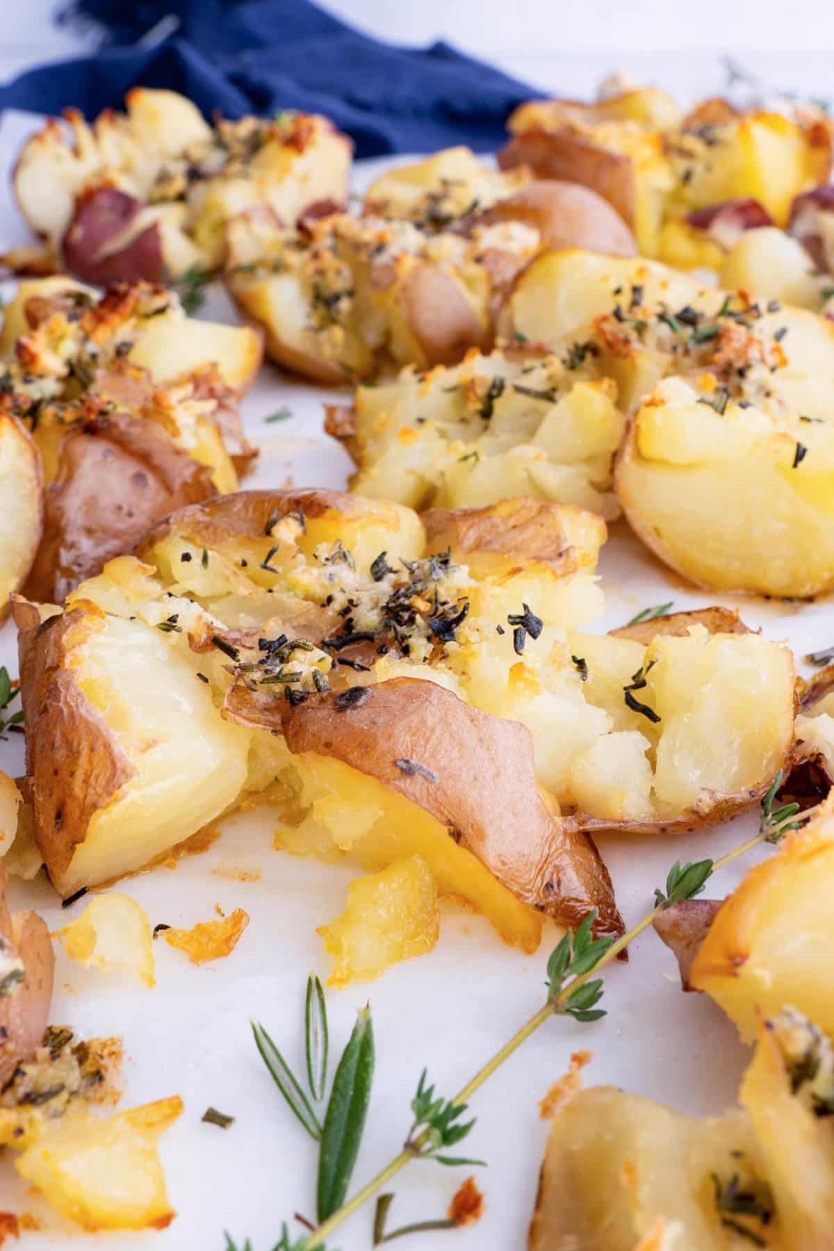 Red potatoes are seasoned with butter and herbs then smashed.