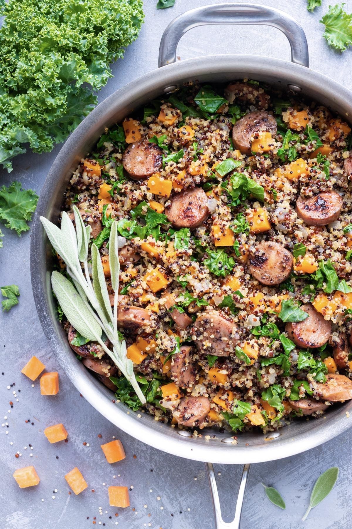 A Fall-inspired healthy quinoa recipe with sage, sweet potatoes, chicken apple sausage, and kale.