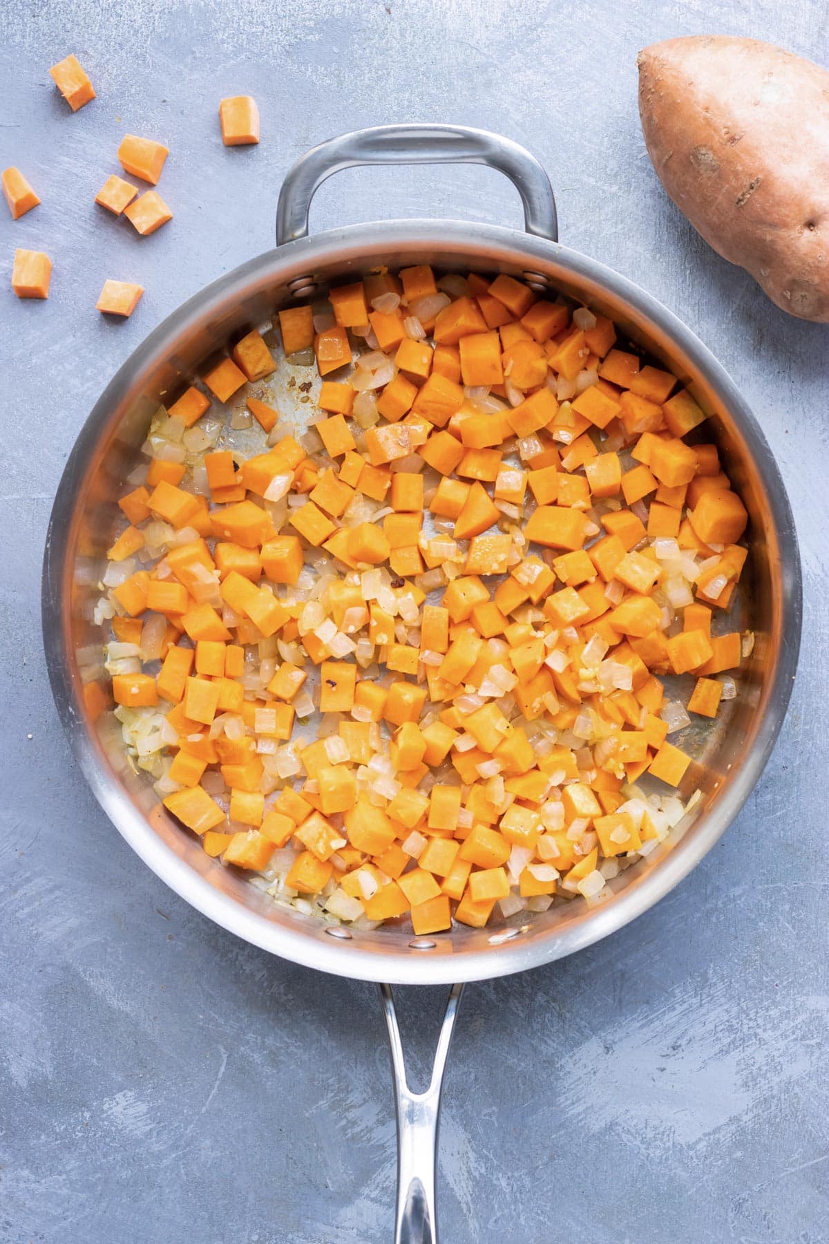Sweet potatoes are cooked in a skillet.