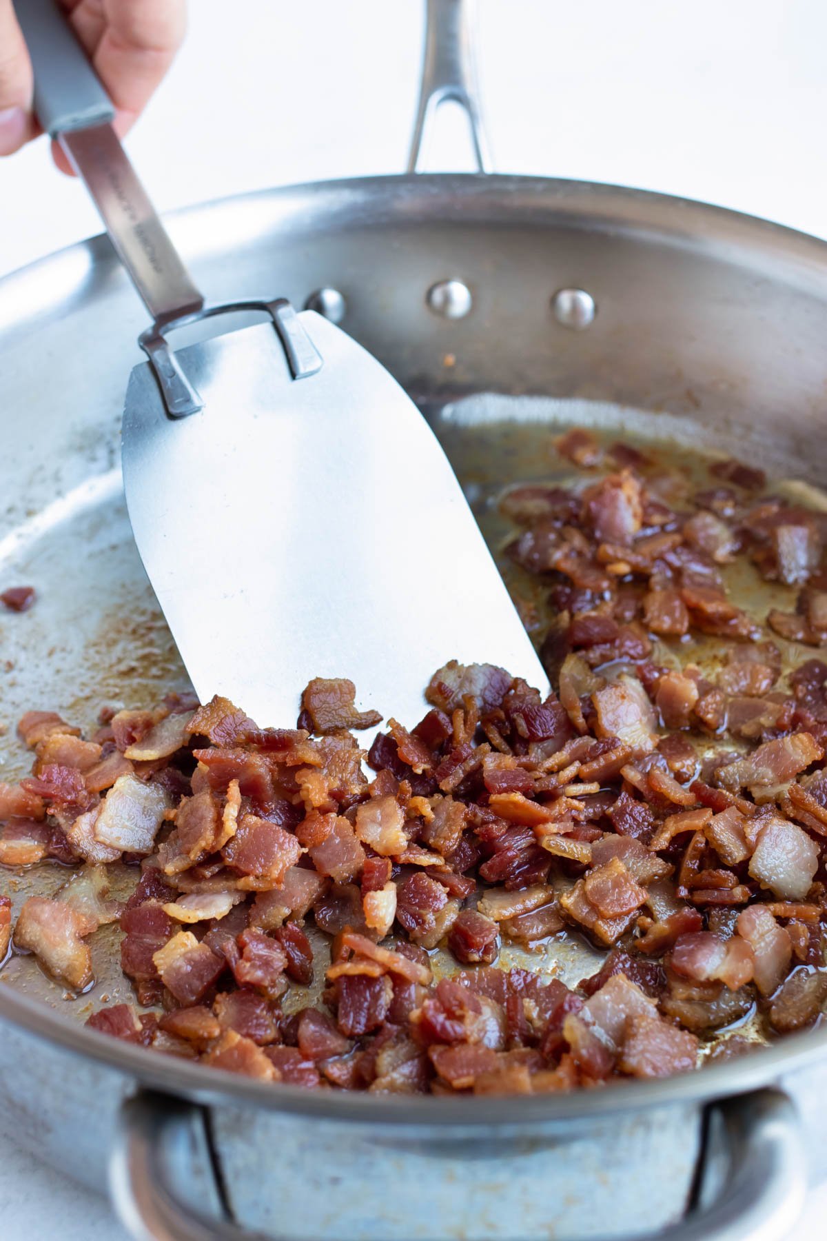 Cook bacon in a skillet until perfectly crispy.