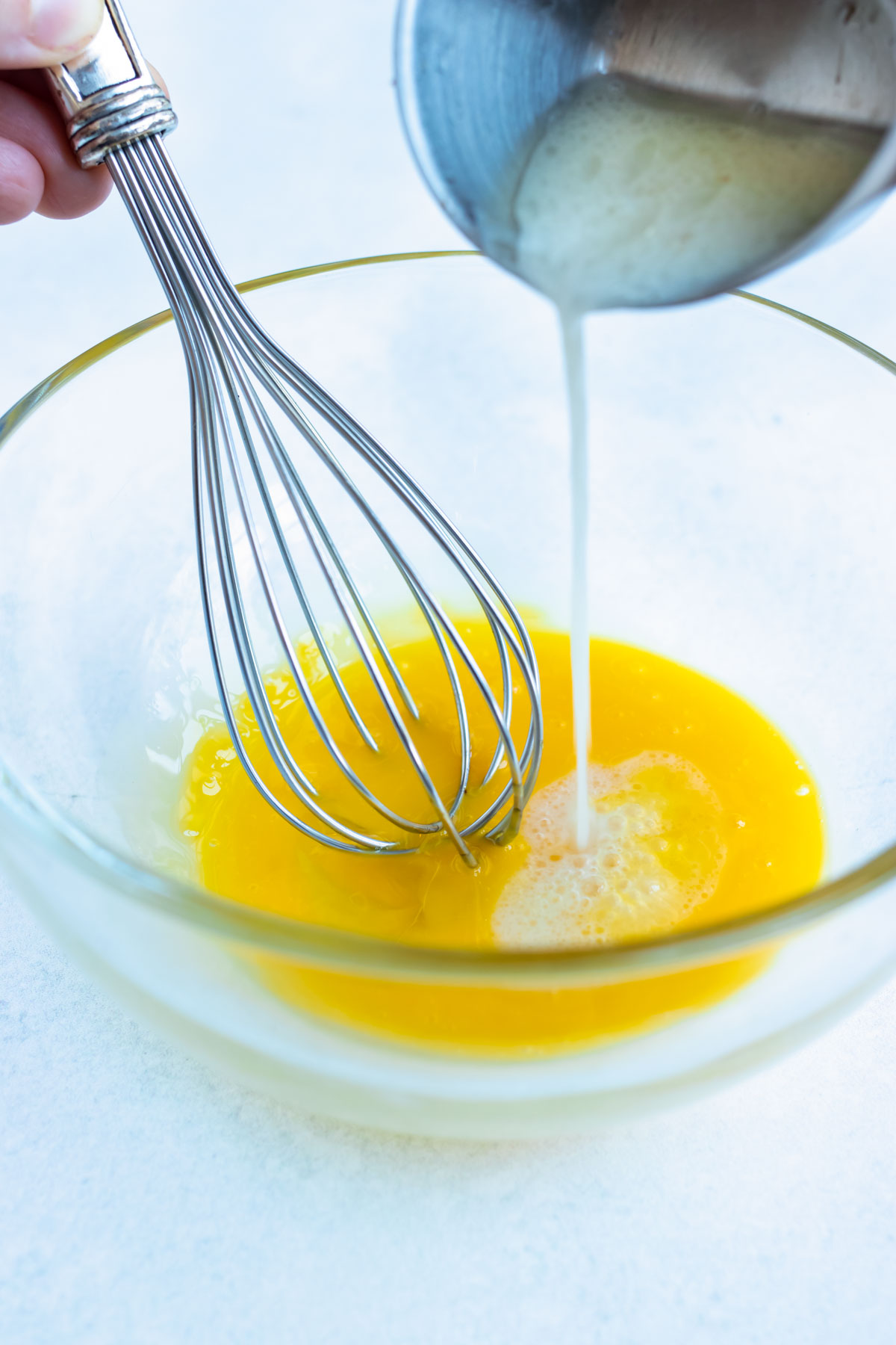 Whisk egg yokes with a few tablespoons of warm milk to temper them.